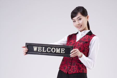 Asian restaurant waitress welcome pose isolated on whiteの写真素材