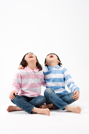 Asian boy and girl looking at sky together isolated on whiteの写真素材