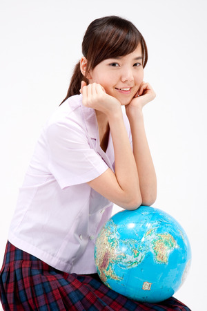 Close up Asian teenager girl with globe isolated on whiteの写真素材