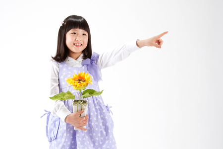 Asian girl pointing something isolated on whiteの写真素材