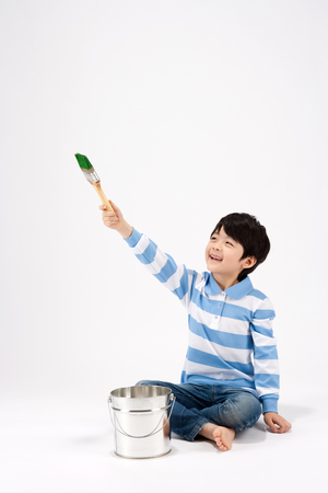 Asian boy painting something isolated on whiteの写真素材