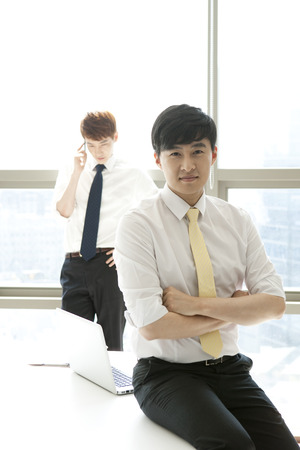 Two Asian business men in officeの写真素材