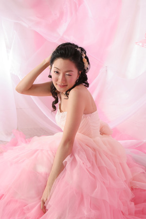 Portrait of Asian cute bride in wedding dress while blinkingの写真素材