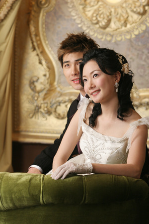 Asian young couple in wedding with happy on chairの写真素材