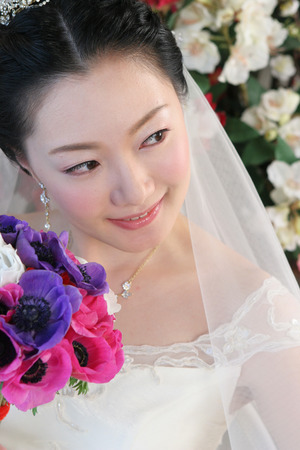 Close up Asian beautiful bride in wedding dress holding bouquetの写真素材