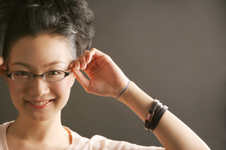 Close up Asian stylish young woman with glasses on black backgroundの写真素材