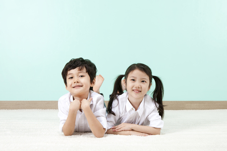 Asian cute boy and girl lying on the floorの写真素材