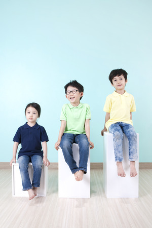 Asian cute children sitting on chair with smileの写真素材