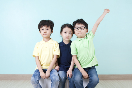 Asian cute children answering the question on chairの写真素材