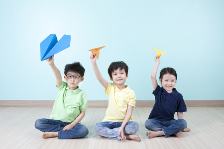 Asian cute children playing with paper airplaneの写真素材
