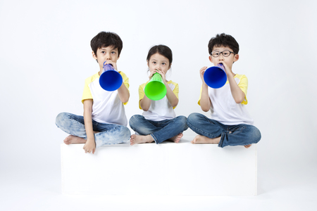 Asian cute children having fun with loudspeaker isolated on whiteの写真素材