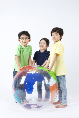 Asian cute children playing with gym ball isolated on whiteの写真素材