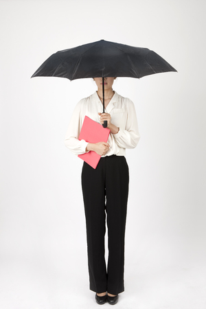Asian business woman holding black umbrella isolated on whiteの写真素材