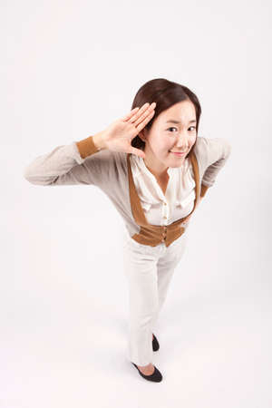 Asian beautiful woman in listening motion isolated on whiteの写真素材