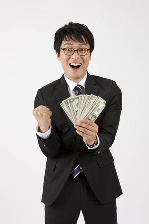 Close up Asian business man looking happy with money isolated on whiteの写真素材