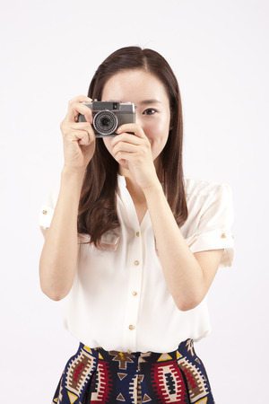 Asian business woman taking picture with joy isolated on whiteの写真素材