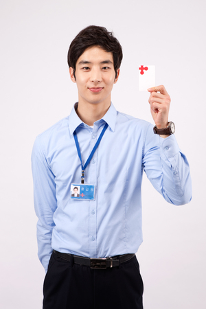 Asian business man holding his business card isolated on whiteの写真素材