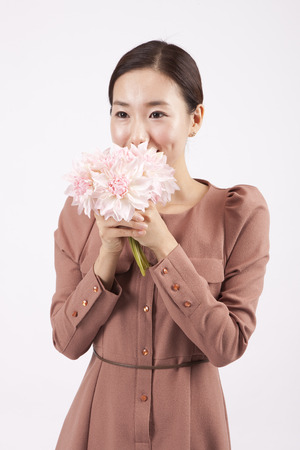 Asian business woman smelling the flower isolated on whiteの写真素材