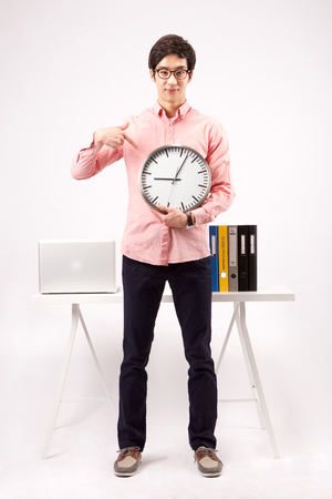 Asian handsome man pointing clock isolated on whiteの写真素材