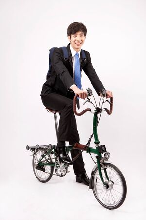 Asian business man riding bicycle isolated on whiteの写真素材