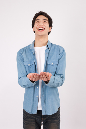 Asian young man giving something motion with smile isolated on whiteの写真素材