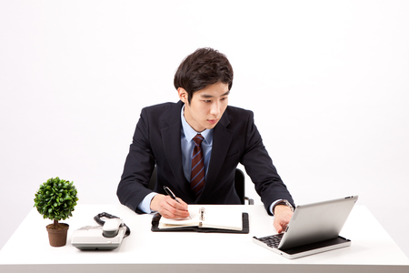 Asian business man do work with tablet pc isolated on whiteの写真素材