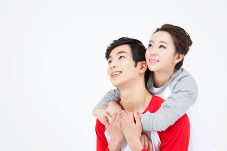 Asian happy couple looking at something together isolated on whiteの写真素材