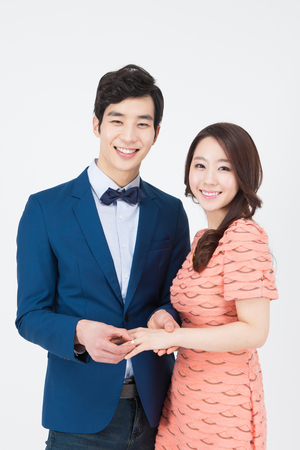 Portrait of Asian couple having romantic time with propose ring isolated on whiteの写真素材