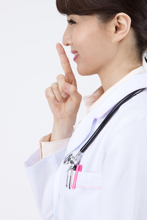 Portrait of Asian female doctor asking silence isolated on whiteの写真素材