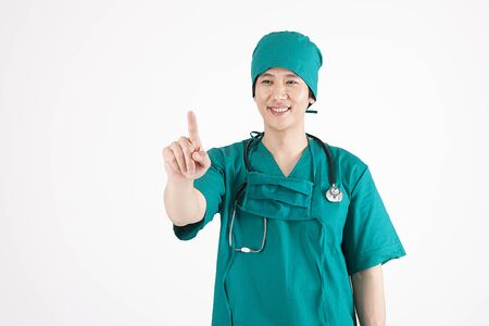 Portrait of Asian male surgeon pointing gesture with smile isolated on whiteの写真素材
