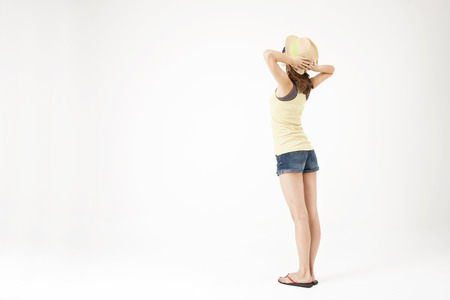 Portrait of rear view Asian beautiful woman in sunglasses and sun hat enjoying summer day isolated on whiteの写真素材