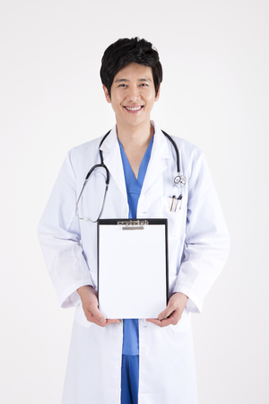 Portrait of Asian handsome doctor holding document with smile isolated on whiteの写真素材