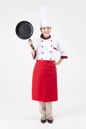Asian female chef holding pan isolated on whiteの写真素材