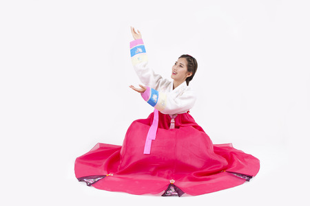 Asian woman in Korean traditional clothes putting her palms up isolated on whiteの写真素材
