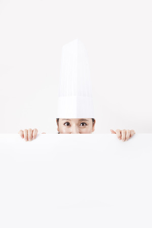 Asian female chef behind white board isolated on whiteの写真素材