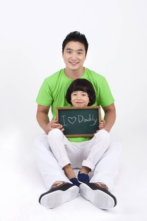 Asian dad and son with board written I love daddy isolated on whiteの写真素材