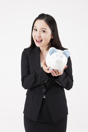 Asian beautiful woman with piggybank isolated on whiteの写真素材