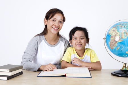 Multicultural family mother and daughter reading book isolated on whiteの写真素材