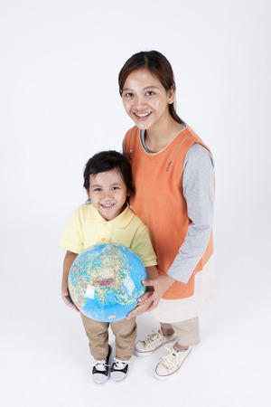 Multicultural family mother and daughter with globe isolated on whiteの写真素材