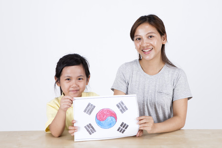 Multicultural family mother and daughter drawing Korean flag isolated on whiteの写真素材