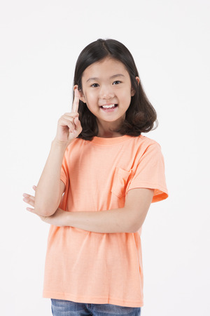Asian female child with pointing gesture isolated on whiteの写真素材