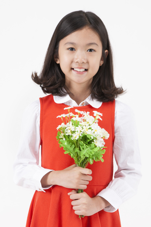 Asian female child with flower isolated on whiteの写真素材
