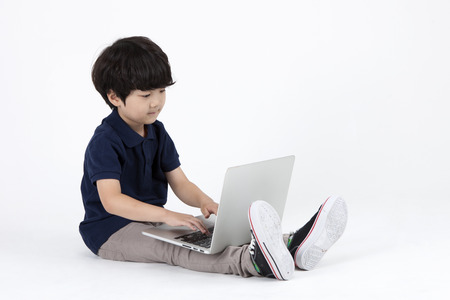 Asian cute boy using laptop on the studio isolated on white