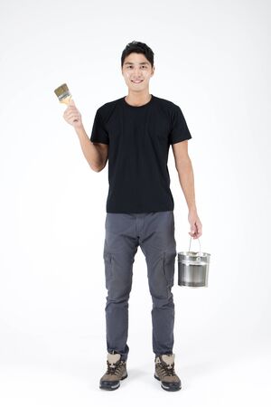 Asian handsome man with paint brush isolated on whiteの写真素材