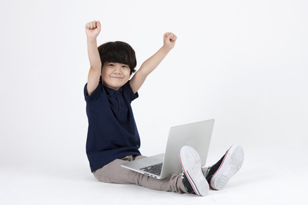 Asian cute boy using laptop isolated on whiteの写真素材