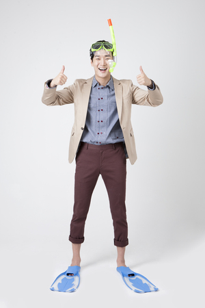 Asian young man with goggles and flippers isolated on whiteのeditorial素材