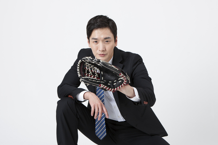 Asian business man playing baseball isolated on whiteの写真素材