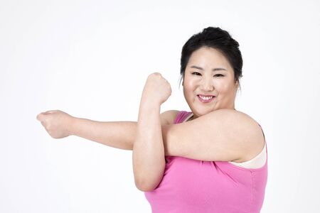 Asian overweigh woman stretching isolated on whiteの写真素材