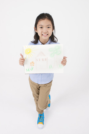 Asian female child with drawings isolated on whiteの写真素材