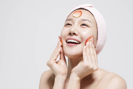 Asian young woman strawberry on her face isolated on whiteの写真素材